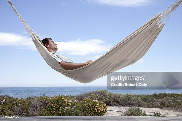 uomo di dormire su un'amaca - hammock foto e immagini stock