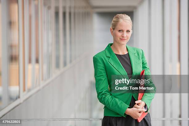 businesswoman carrying file - groen jak stockfoto's en -beelden