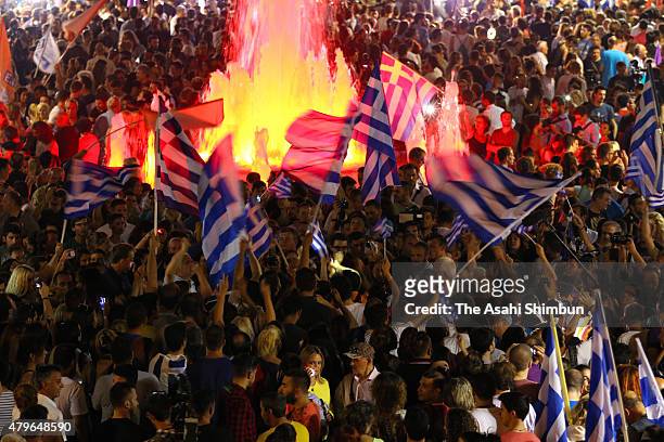 Eople celebrate in front of the Greek parliament as the people of Greece reject the debt bailout by creditors on July 6, 2015 in Athens, Greece. The...