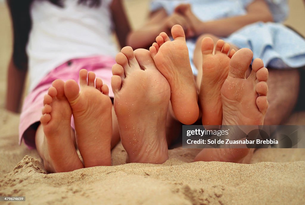 Family feet at the beach