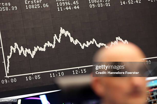 Trader on the trading floor of the Frankfurt Stock Exchange as a graph shows the day's performance of the DAX index the day after the 'NO' vote in...