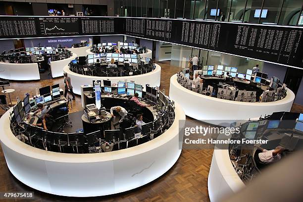 Traders on the trading floor of the Frankfurt Stock Exchange as a graph shows the day's performance of the DAX index the day after the 'NO' vote in...