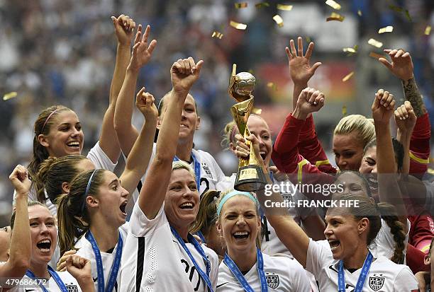 Teammates hold the trophy following the teams' win in the final 2015 FIFA Women's World Cup match between USA and Japan at the BC Place Stadium in...