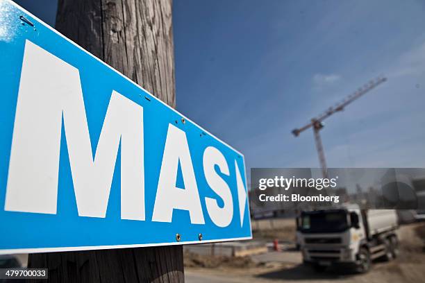 Sign for real estate developer Serge Mas Promotion points towards a construction truck and crane on a building site at the Vidailhan eco area...