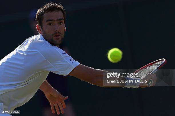 Croatia's Marin Cilic returns to US player Denis Kudla during their men's singles fourth round match on day seven of the 2015 Wimbledon Championships...