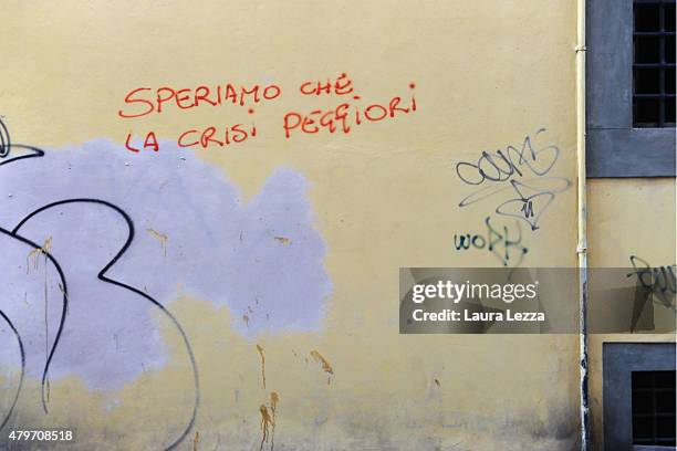 Graffiti which reads 'We hope the crisis is getting worse' is seen the day after Greece's austerity referendum which dominates the Italian front...