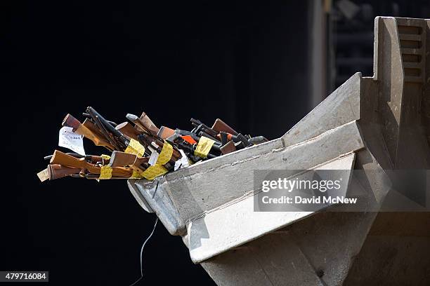 Front loader tractor carries guns to the melt shop during the destruction of approximately 3,400 guns and other weapons at the Los Angeles County...