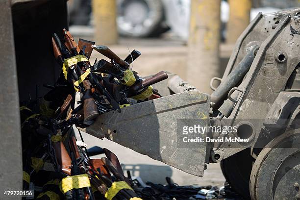 Tractors scoop up guns during the destruction of approximately 3,400 guns and other weapons at the Los Angeles County Sheriffs' 22nd annual gun melt...