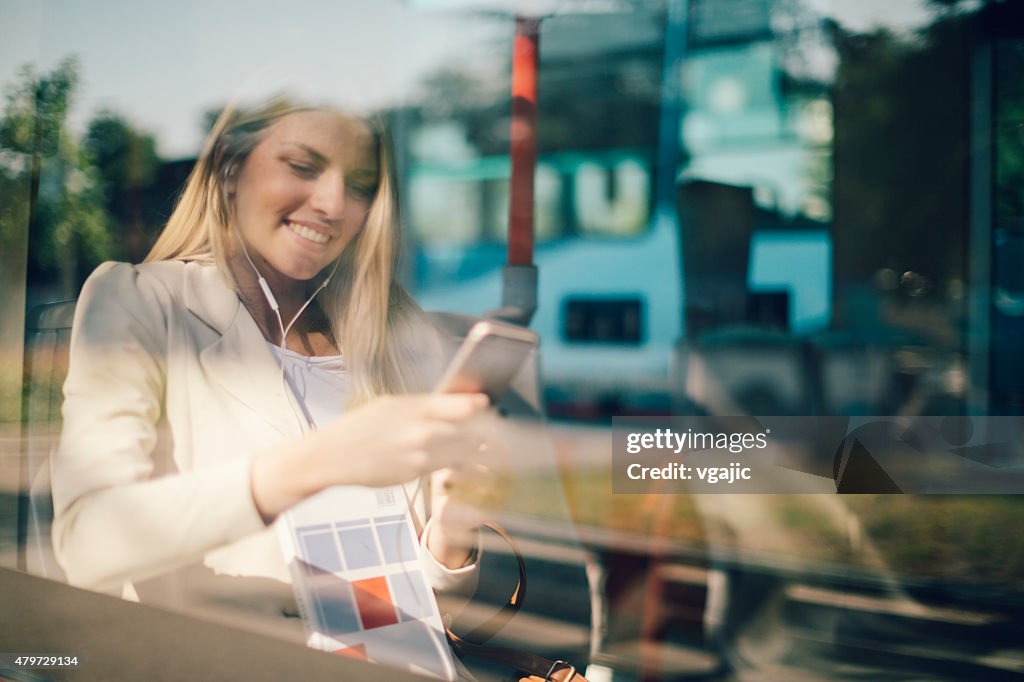 Young Woman Typing On Her Smart Phone In Public Transportation.