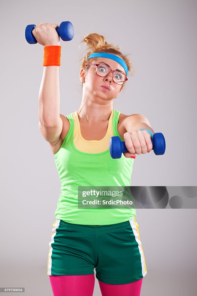 Nerd fitness girl wearing glasses exercising with small weights