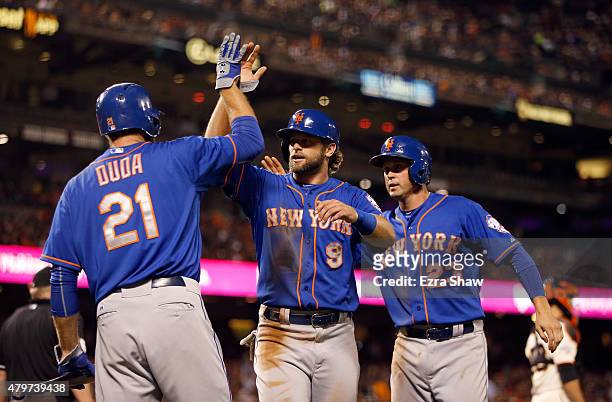 Kirk Nieuwenhuis and Michael Cuddyer of the New York Mets are congratulated by Lucas Duda of the New York Mets after they both scored in the ninth...