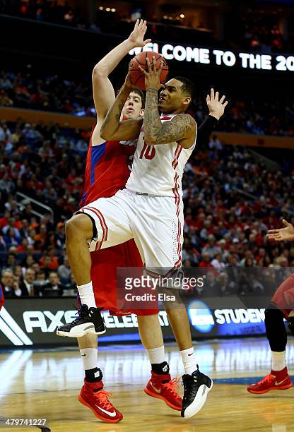 LaQuinton Ross of the Ohio State Buckeyes goes to the basket as Matt Kavanaugh of the Dayton Flyers defends during the second round of the 2014 NCAA...
