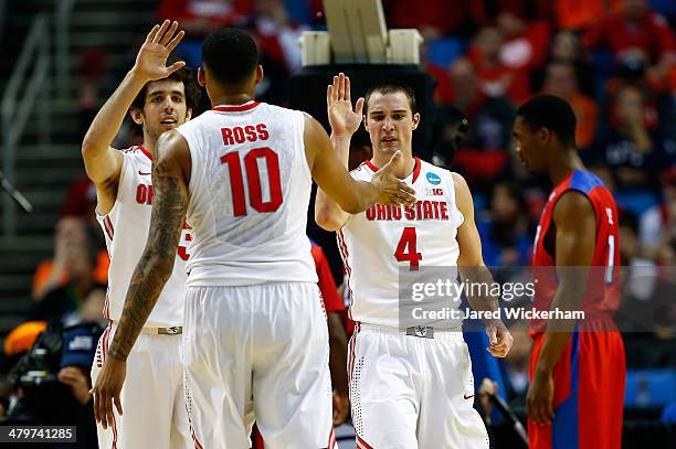 LaQuinton Ross celebrates with Amedeo Della Valle and Aaron Craft of the Ohio State Buckeyes against the Dayton Flyers during the second round of the...