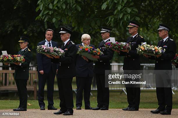 British Prime Minister David Cameron and London Mayor Boris Johnson watch as representatives of the ambulance, fire and police services lay wreaths...