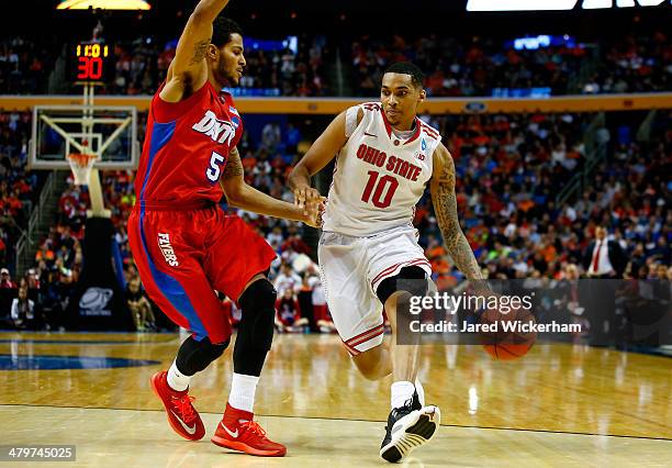 LaQuinton Ross of the Ohio State Buckeyes drives to the basket as Devin Oliver of the Dayton Flyers defends during the second round of the 2014 NCAA...