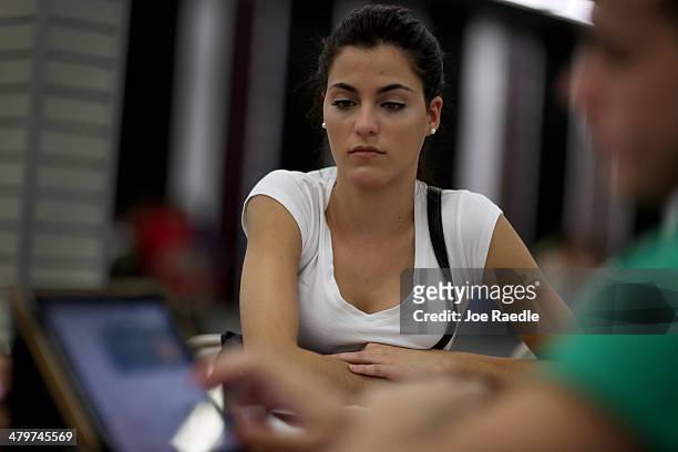 Yislaine Diaz sits with Amaury Garcia an insurance agent from Sunshine Life and Health Advisors as she purchases an individual health insurance...