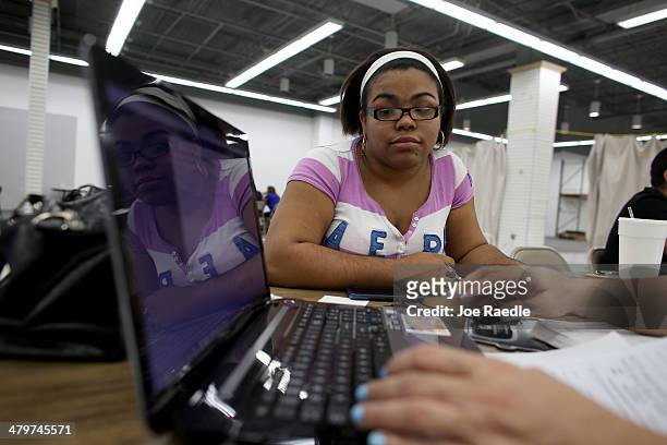 Wendy Gonzalez sits with, Maria Mena, an insurance agent from Sunshine Life and Health Advisors as she purchases a health insurance policy under the...