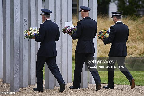 Senior members of the emergency services including Metropolitan Police Commissioner Sir Bernard Hogan-Howe take part in a wreath laying ceremony in...