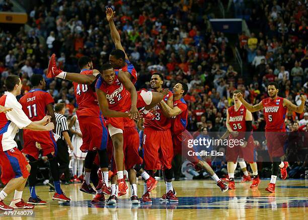 The Dayton Flyers celebrate after defeating the Ohio State Buckeyes 60-59 in the second round of the 2014 NCAA Men's Basketball Tournament at the...