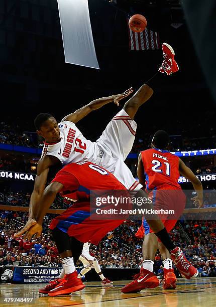 Sam Thompson of the Ohio State Buckeyes gets tangled with Khari Price of the Dayton Flyers under the basket during the second round of the 2014 NCAA...