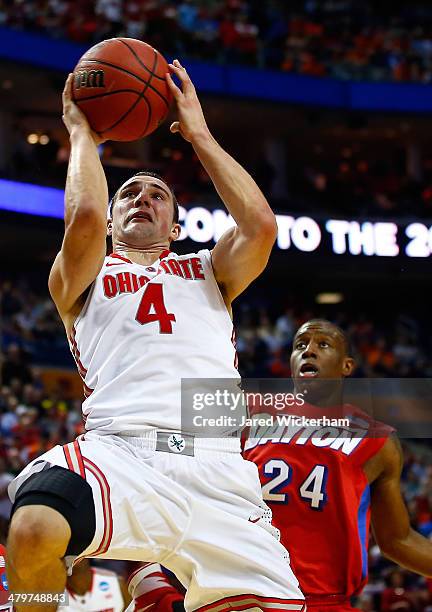 Aaron Craft of the Ohio State Buckeyes goes up for a shot as Jordan Sibert of the Dayton Flyers defends during the second round of the 2014 NCAA...