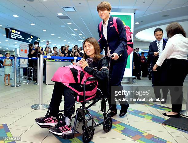 Kozue Ando of Japan on the wheelchair is pushed by Erina Yamane on departure at Vancouver International Airport on July 6, 2015 in Vancouver, Canada.
