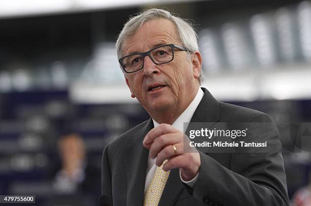 Jean-Claude Juncker, President of the European Commission, speaks as members of the right wing section of the parliament hold placards agains the...