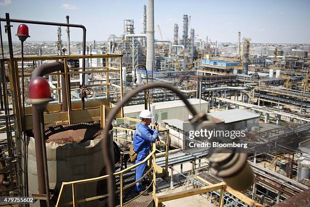 Worker speaks on a radio as he inspects a platform high above the Atyrau oil refinery, operated by KazMunaiGas National Co., in Atyrau, Kazakhstan,...