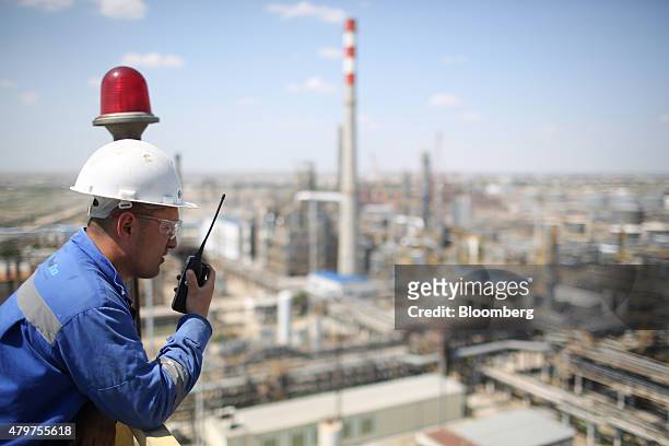 Worker speaks on a radio as he inspects a platform high above the Atyrau oil refinery, operated by KazMunaiGas National Co., in Atyrau, Kazakhstan,...