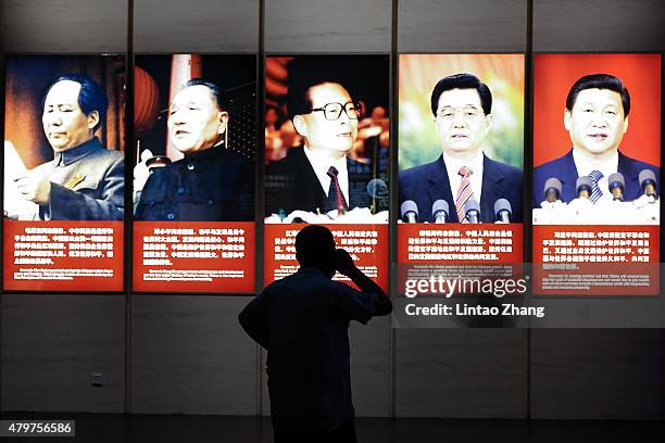 Visitor looks on front portraits of former Chinese leaders Mao Zedong, Deng Xiaoping, Jiang Zemin, Hu Jintao and current President Xi Jinping are...