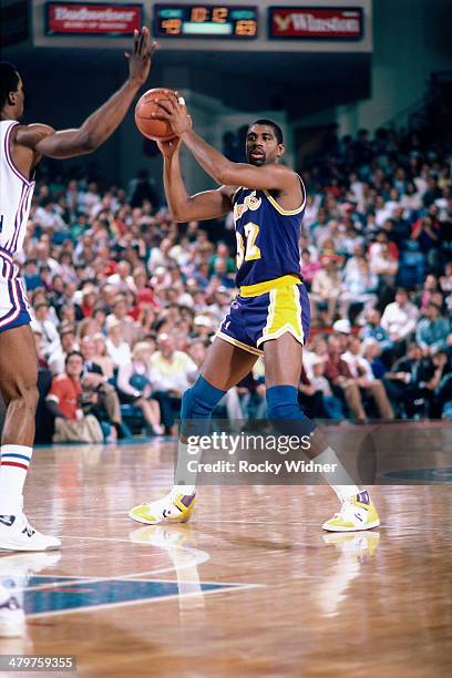 Magic Johnson of the Los Angeles Lakers passes the ball during a game played circa 1987 at Arco Arena in Sacramento, California. NOTE TO USER: User...