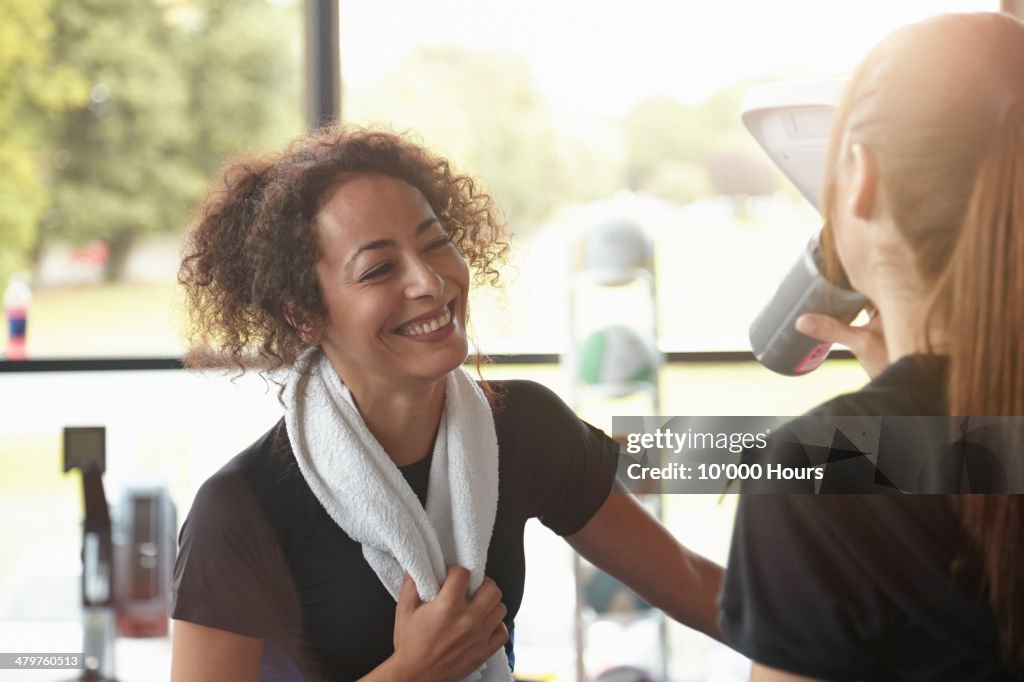 Two women in a gym chatting