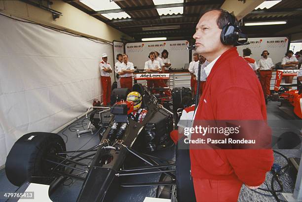 Team principle Ron Dennis looks on as Ayrton Senna sits aboard the Honda Marlboro McLaren McLaren MP4/6 Honda RA121E V12 during practice for the...