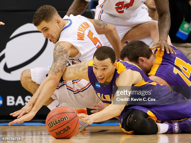 Gary Johnson of the Albany Great Danes and Scottie Wilbekin of the Florida Gators go after a loose ball in the second half during the second round of...
