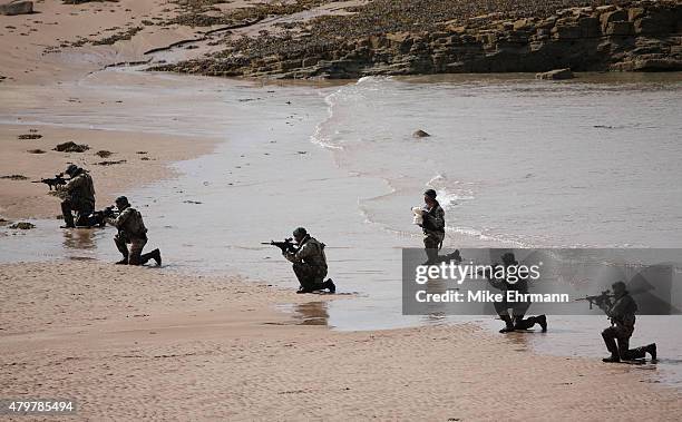 Troop of Royal Marines from the 43 Commando land on a beach via the Firth of Forth to deliver the Scottish Open trophy for 'safe keeping' prior to...