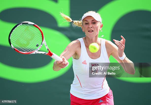 Olga Govortsova of Belarus returns a shot to Flavia Pennetta of Italy during their match on day 4 of the Sony Open at Crandon Park Tennis Center on...