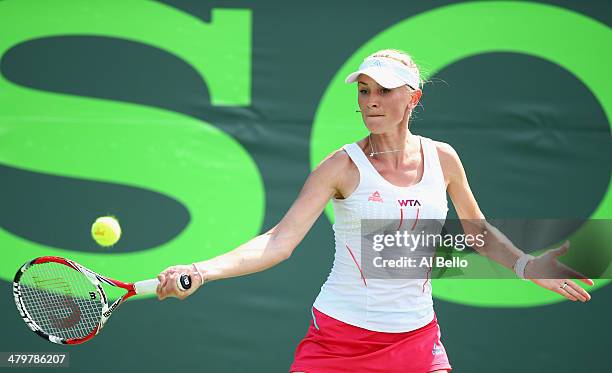 Olga Govortsova of Belarus returns a shot to Flavia Pennetta of Italy during their match on day 4 of the Sony Open at Crandon Park Tennis Center on...