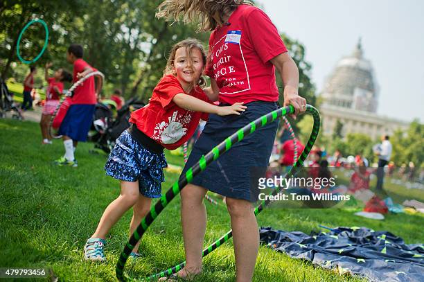 Olivia Yost of Pittsburgh, hugs her mother Cyrstal, during a "play-in" protest by kids and mothers in Upper Senate Park organized by Moms Clean Air...