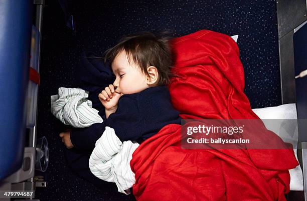 young boy sleeping on airplane floor - jet lag stockfoto's en -beelden