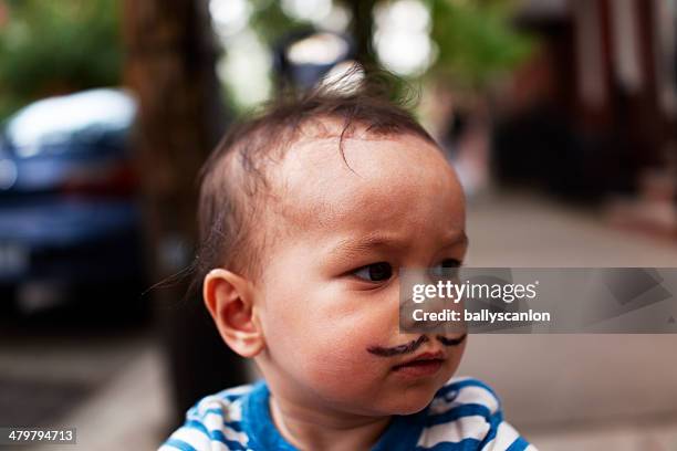 toddler with fake moustache - alleen één jongensbaby stockfoto's en -beelden
