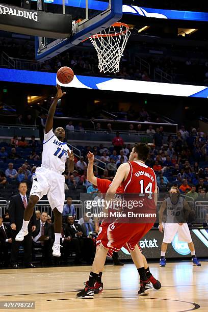 Mike McCall Jr. #11 of the Saint Louis Billikens takes a jump shot against Tyler Lewis and Jordan Vandenberg of the North Carolina State Wolfpack...