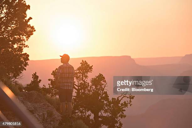 Visitor looks out from Hopi Point as the sun sets at Grand Canyon National Park in Grand Canyon, Arizona, U.S., on Wednesday, June 24, 2015. The...