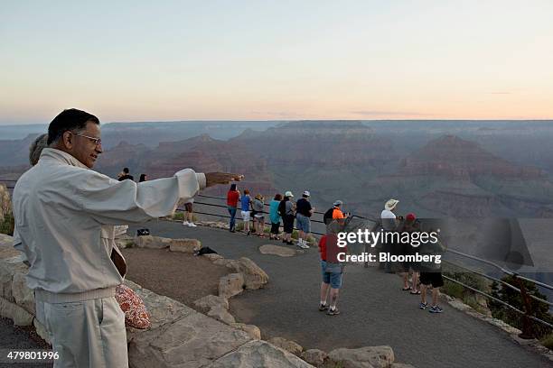 Visitors look out from Hopi Point at sunrise in Grand Canyon National Park in Grand Canyon, Arizona, U.S., on Thursday, June 25, 2015. The Grand...