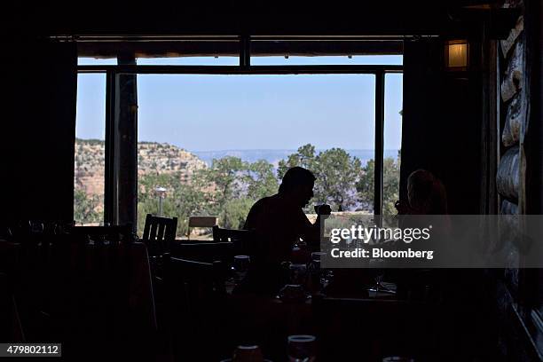 The silhouette of a visitor is seen drinking coffee in the dining room of the El Tovar Hotel in the Grand Canyon Village area of Grand Canyon...