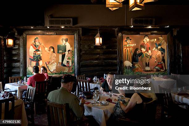 Murals depicting two Native American Tribes, the Hopi and the Navajo, hang on the walls as visitors eat in the dining room of the El Tovar Hotel in...