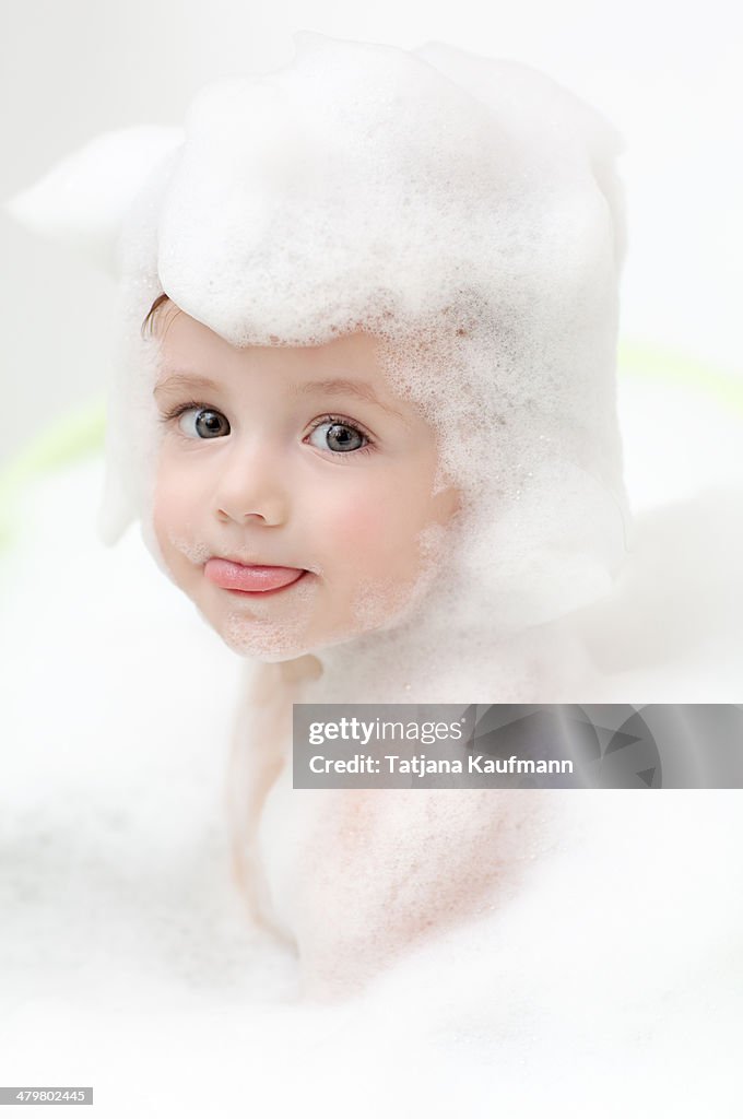 Cute Baby in Bathtub stretching out Tongue