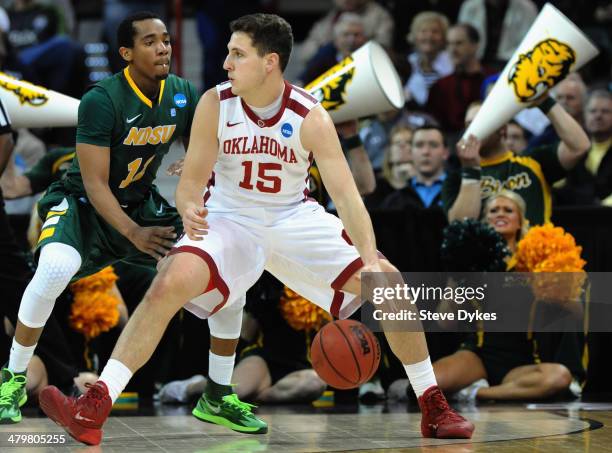 Tyler Neal of the Oklahoma Sooners dribbles against Lawrence Alexander of the North Dakota State Bison during the second round of the 2014 NCAA Men's...