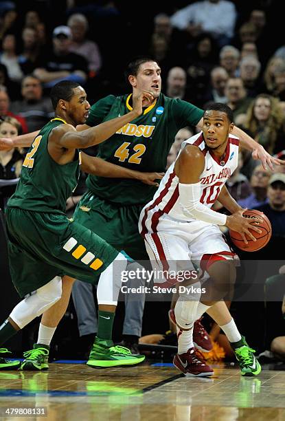 Lawrence Alexander and Marshall Bjorklund of the North Dakota State Bison defend Jordan Woodard of the Oklahoma Sooners during the second round of...