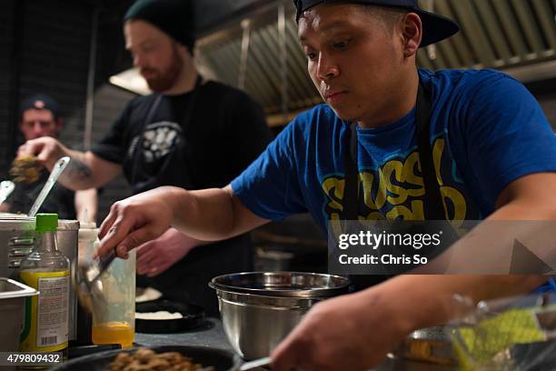 Line cook Marcus Envidia batters some cod prior to frlying. Corey Mintz works a busy Thursday night at La Carnita restaurant 780 Queen Street East.