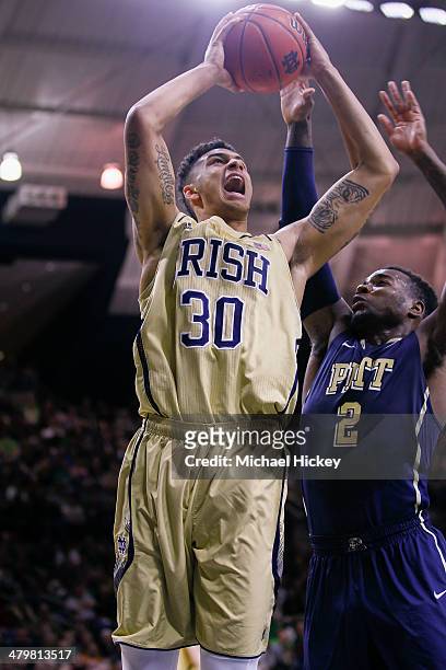 Zach Auguste of the Notre Dame Fighting Irish shoots the ball against Michael Young of the Pittsburgh Panthers at Purcel Pavilion on March 1, 2014 in...